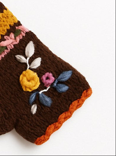 A pair of brown knit fingerless gloves with colorful striped bands and floral embroidery, displayed on a clean white background.