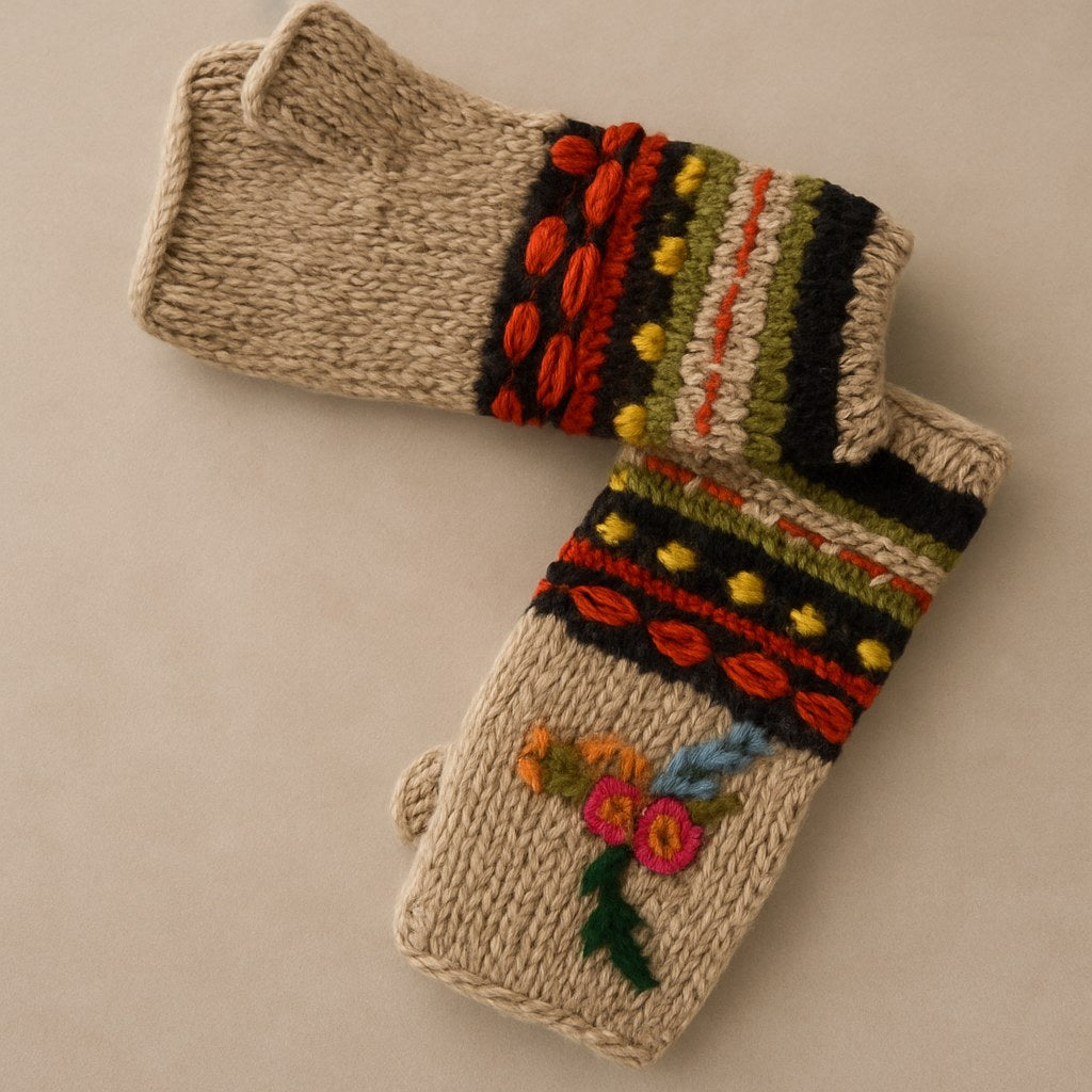 Hand-knitted winter mittens in a warm beige wool, featuring colorful striped and patterned cuffs with red, orange, green, yellow, and black yarn, and embroidered flowers on the front.